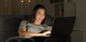 A girl happily online using her laptop