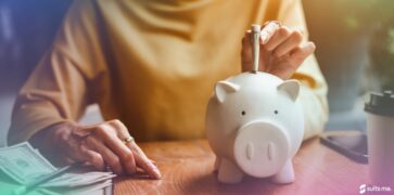 Person putting money into their savings pot