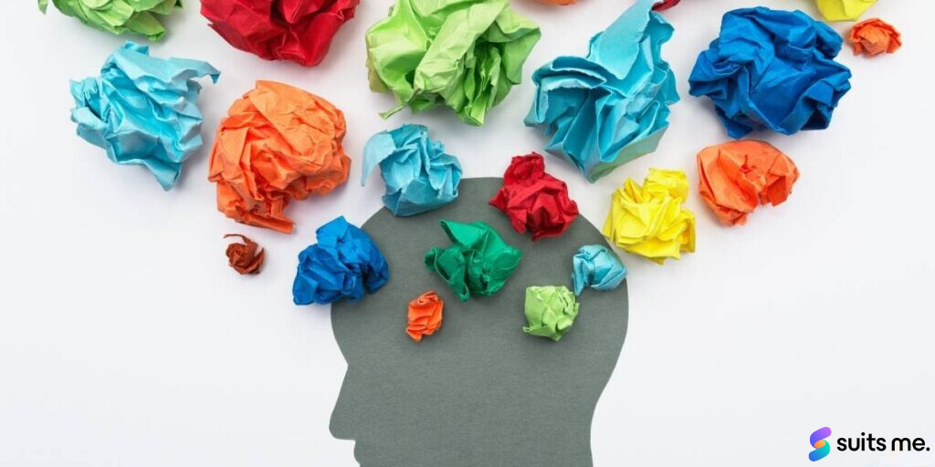 Silhouette of a head with numerous pieces of paper screwed up to signify a boost in mental wellbeing